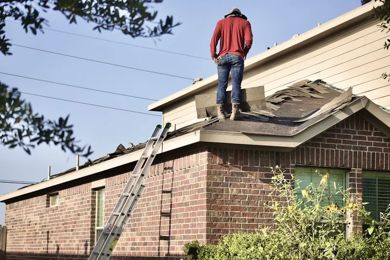 Professional roofer working on a residential roof in Janie Poe